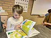 Kind im Kindergarten Hadersleben blättert in buntem Bilderbuch