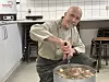 Günter Haagensen in Profikochuniform rührt in großem Suppentopf in der Schulküche der Ludwig-Andresen-Schule in Tondern.