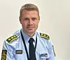 Dänischer Polizeibeamter in hellblauer Uniform mit Abzeichen vor hellem Hintergrund