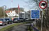 Fahrzeuge im Stau vor einem Dänemark-Grenzschild am Übergang Kruså