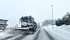Schneepflug räumt eine schneebedeckte Landstraße bei winterlichem Wetter
