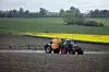 Traktor mit Sprühanlage bearbeitet ein Feld bei Ringsted in ländlicher Umgebung.