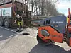 Straßenarbeiter repariert ein Schlagloch neben einer HAMM-Walze und einem Asphalt-Lkw