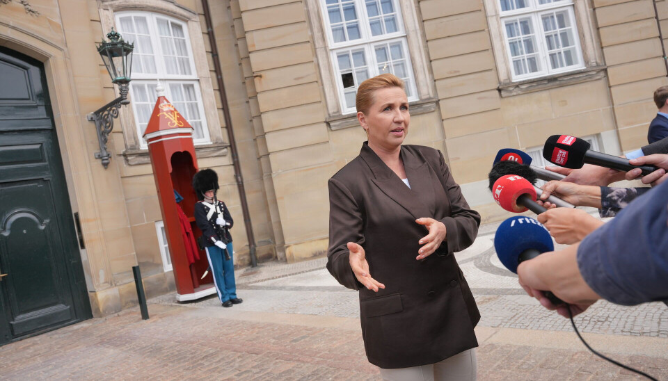 Mette Frederiksen spricht vor Schloss Amalienborg in Kopenhagen zu mehreren Mikrofonen.