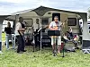 Eine Band spielt im Vorzelt eines Campingwagens Musik